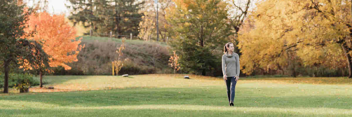 banner - woman walking on parkland