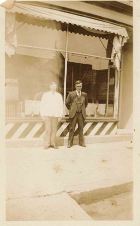 Two men standing in front of a barbershop in Tillsonburg.