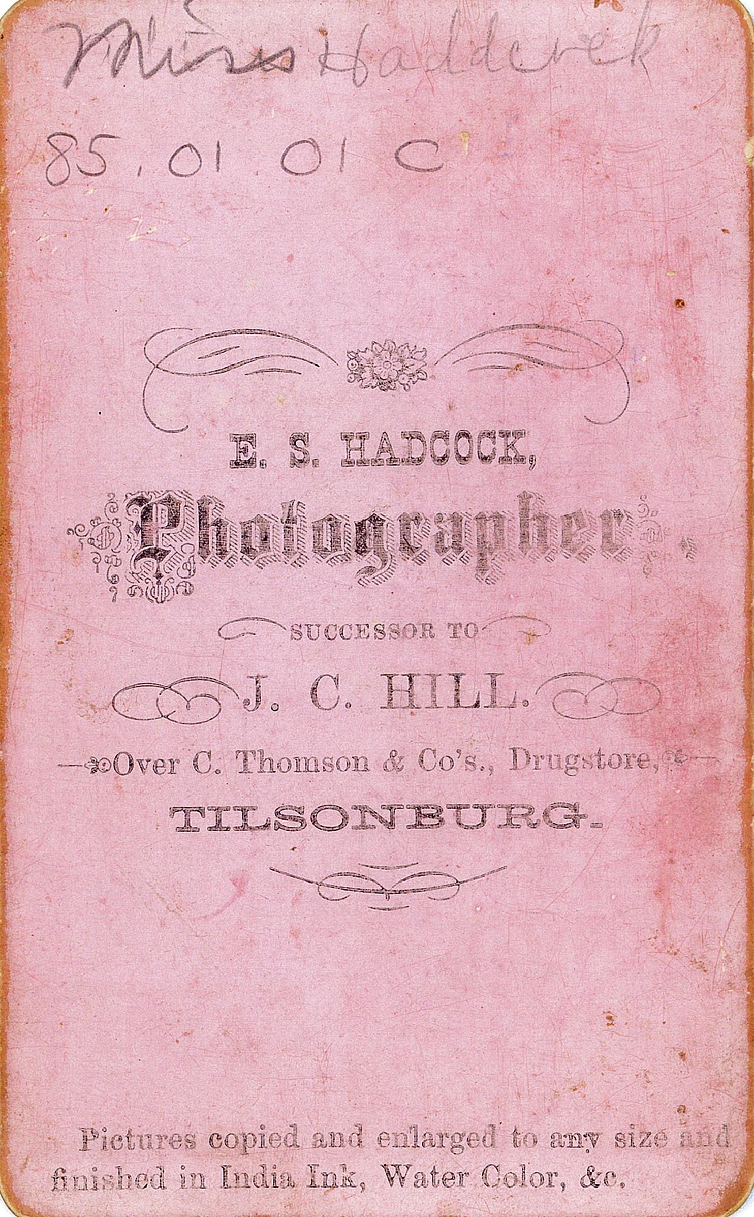 Back of a pink cabinet card from photographer E.S. Hadcock. "Successor to J.C. Hill. Over C. Thomson & Co. Drug Store, Tillsonburg."